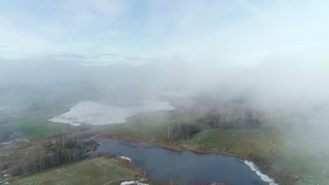 Aerial-view-through-the-clouds-on-rural-countryside-landscape