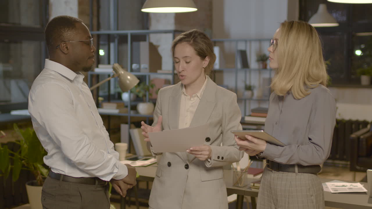 Group Of Three  Employees Standing In The Office And Discussing Together About Business Strategy 1
