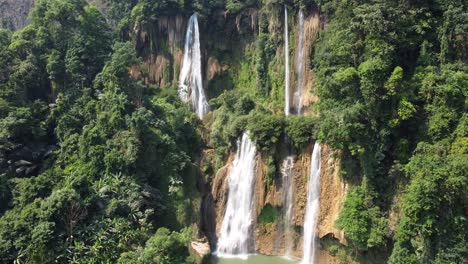 4K-drone-shot,-rotating-around-Thi-Lo-Su-Waterfall-in-the-adventures-peaceful-jungle-of-Umphang,-located-in-the-backpacker-country-of-Thailand-in-Southeast-Asia