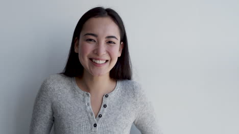 Pretty-Young-Woman-Making-Cute-Faces,-Smiling-And-Looking-At-Camera-With-A-White-Background