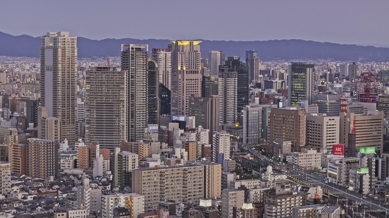 Osaka Japan Aerial v13 zoomed drone low flyover Nakatsu, Toyosaki and Chayamachi capturing the densely populated Kita ward downtown cityscape under dusk sky - Shot with Mavic 3 Pro Cine - Oct 8th 2023