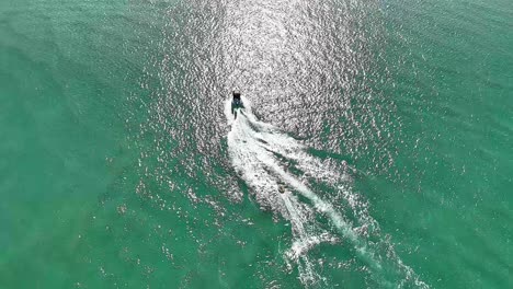 un barco crea olas en un río soleado