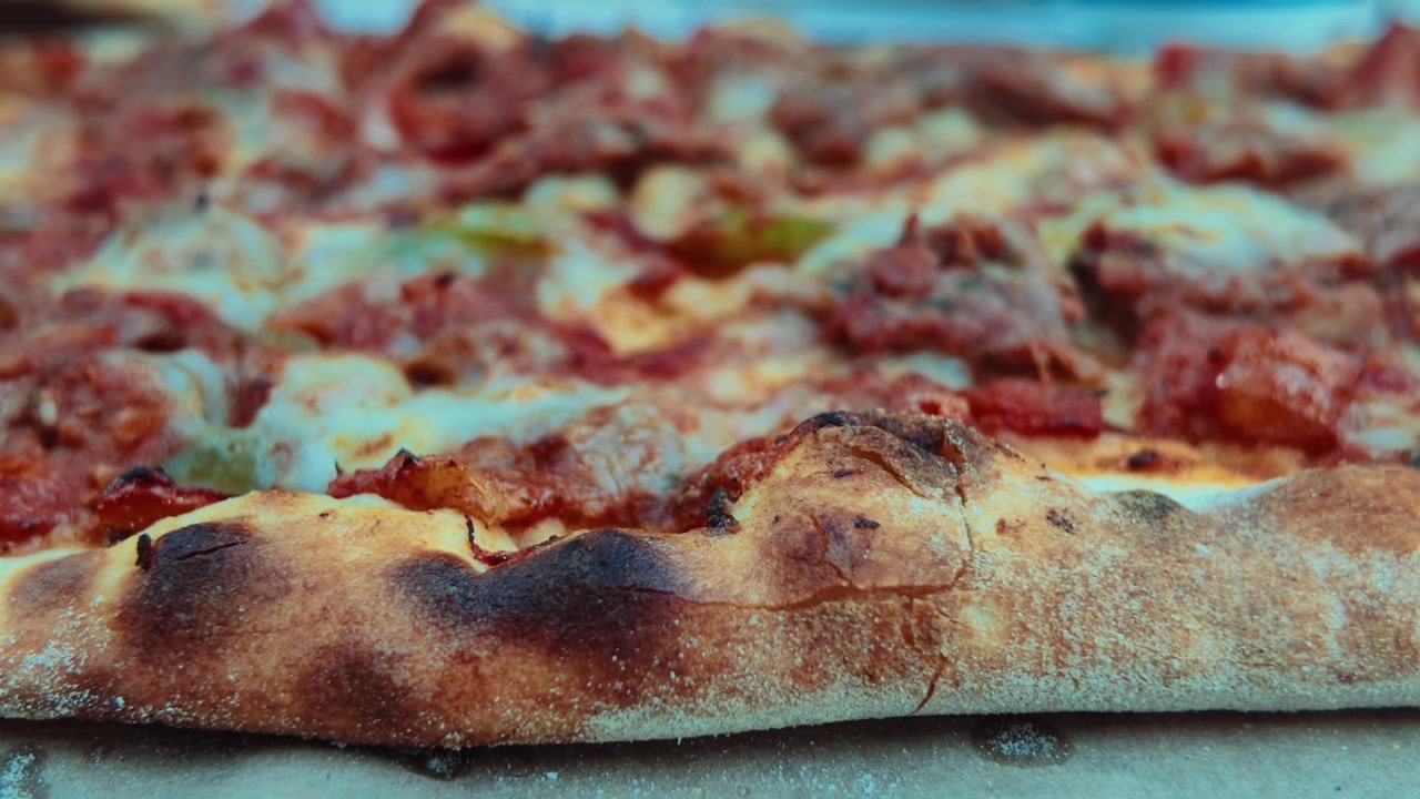 Primo piano di una pizza appena sfornata con condimenti