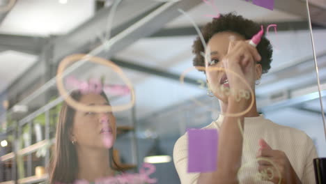 Young-African-American-woman-and-biracial-woman-brainstorm-in-a-business-office