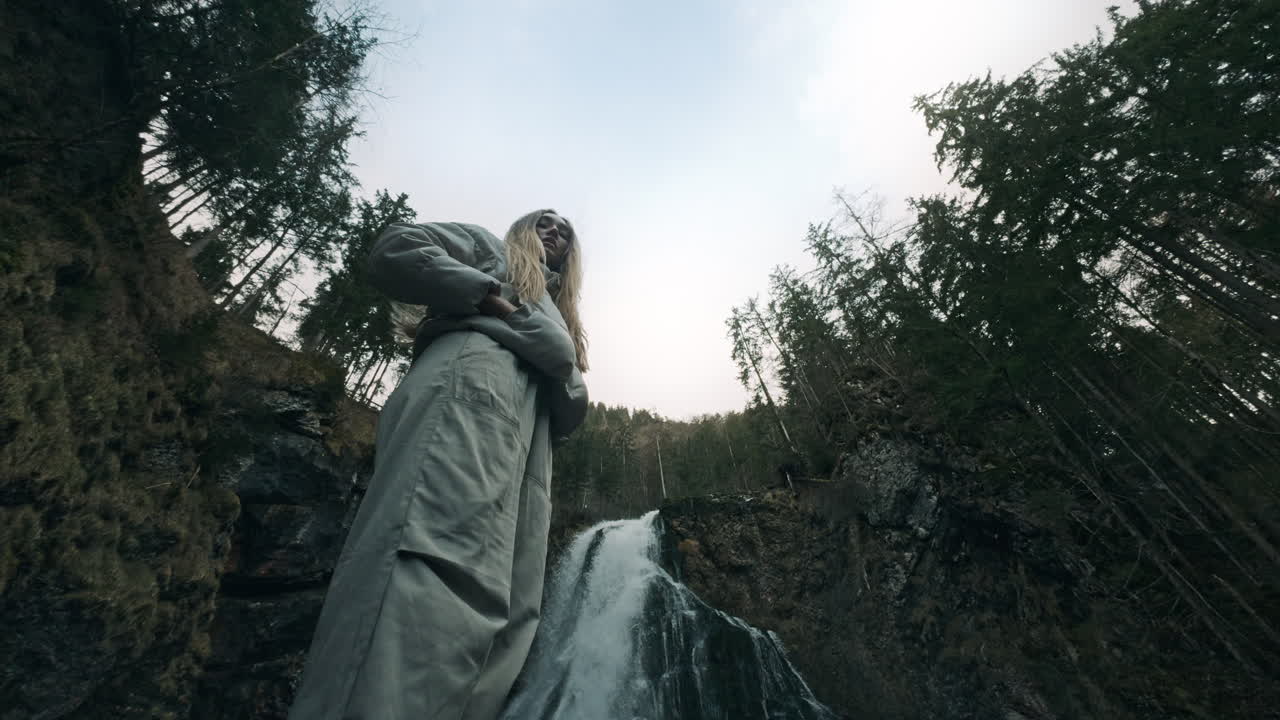 Woman Posing near a Waterfall in a Forest
