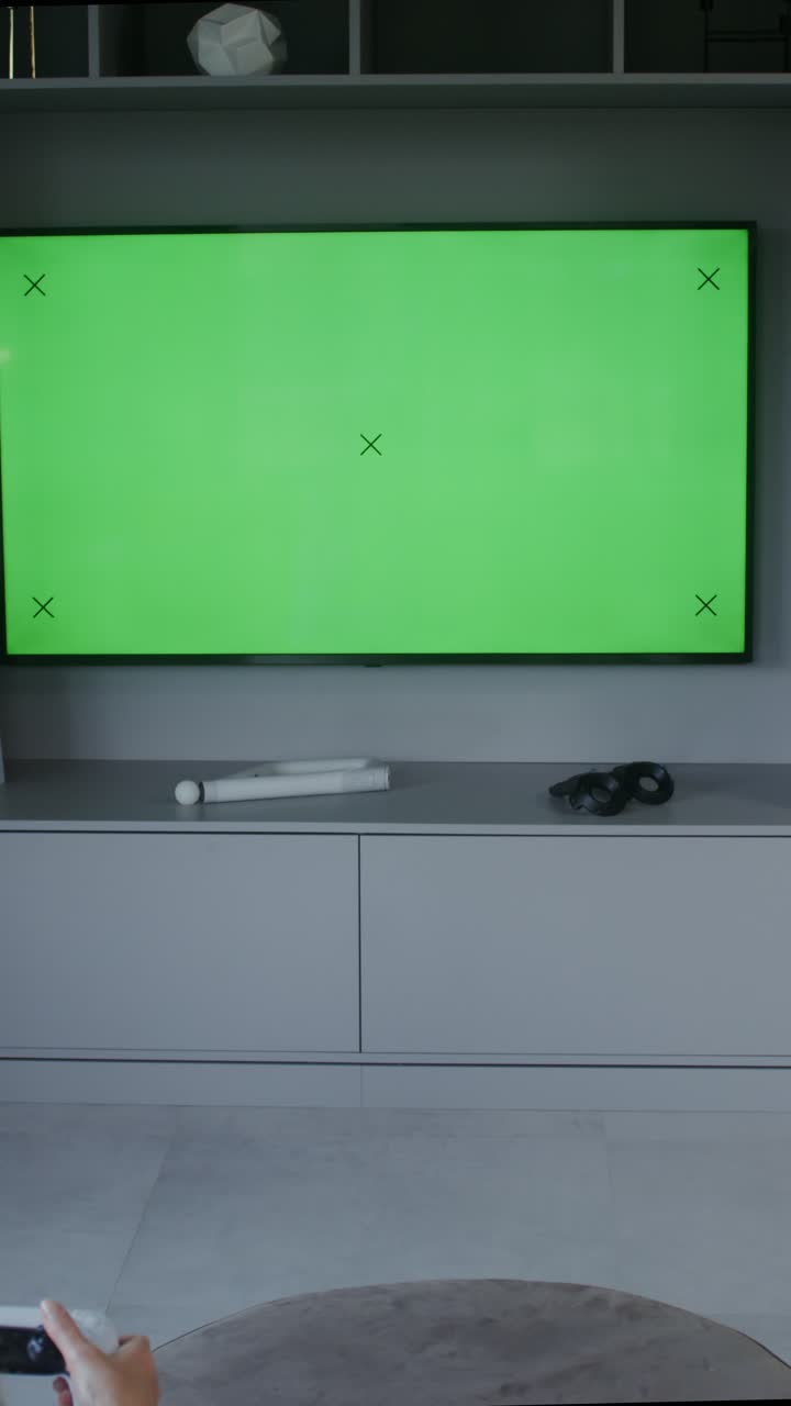 Immagine di una TV con uno sfondo verde e una console di gioco