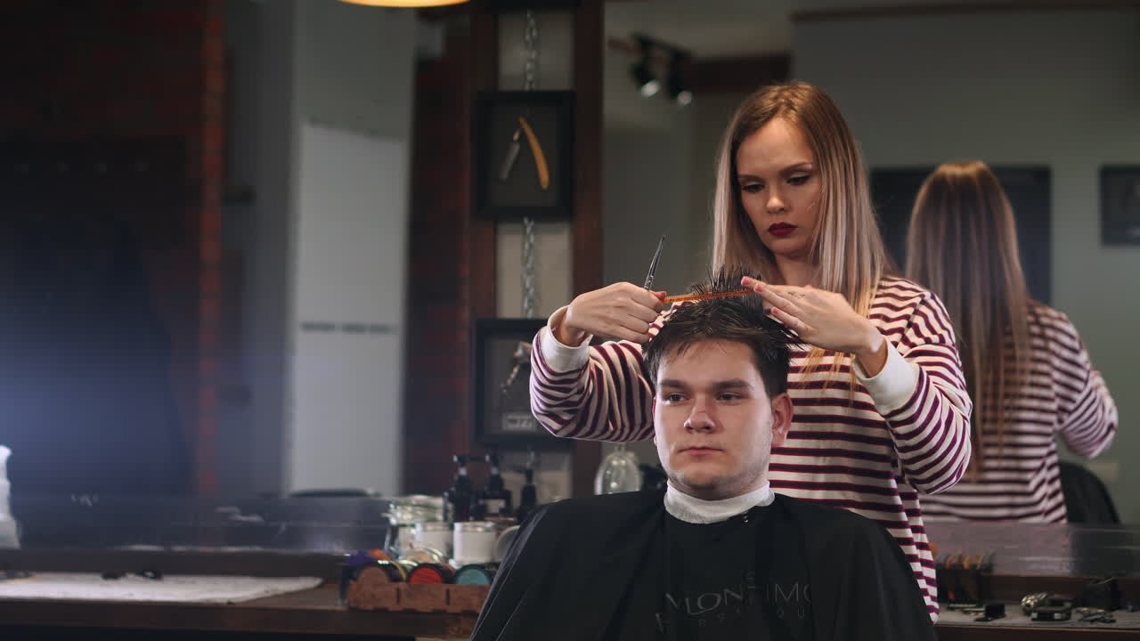 peluquera cortando el cabello de un hombre sonriente cliente en un salón de belleza