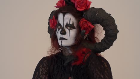 catrina cosplay girl moving hands slowly in a light background, medium close up