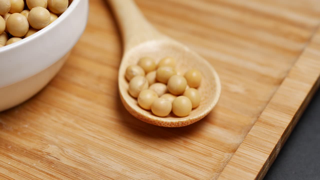 Fagioli di soia in un cucchiaio di legno e una ciotola