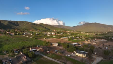 vista aérea ascendente del campo rural de tierras de cultivo en colinas verdes onduladas