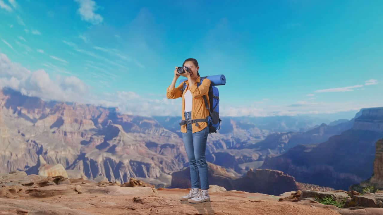 Full Body Side View Of Asian Female Hiker With Mountaineering Backpack Using A Camera Taking Picture While Traveling At The Top Of Mountain