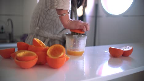 Mujer-Usando-Exprimidor-De-Naranja,-Exprimidor,-Escariador-Preparando-Un-Jugo-De-Naranja-En-Casa