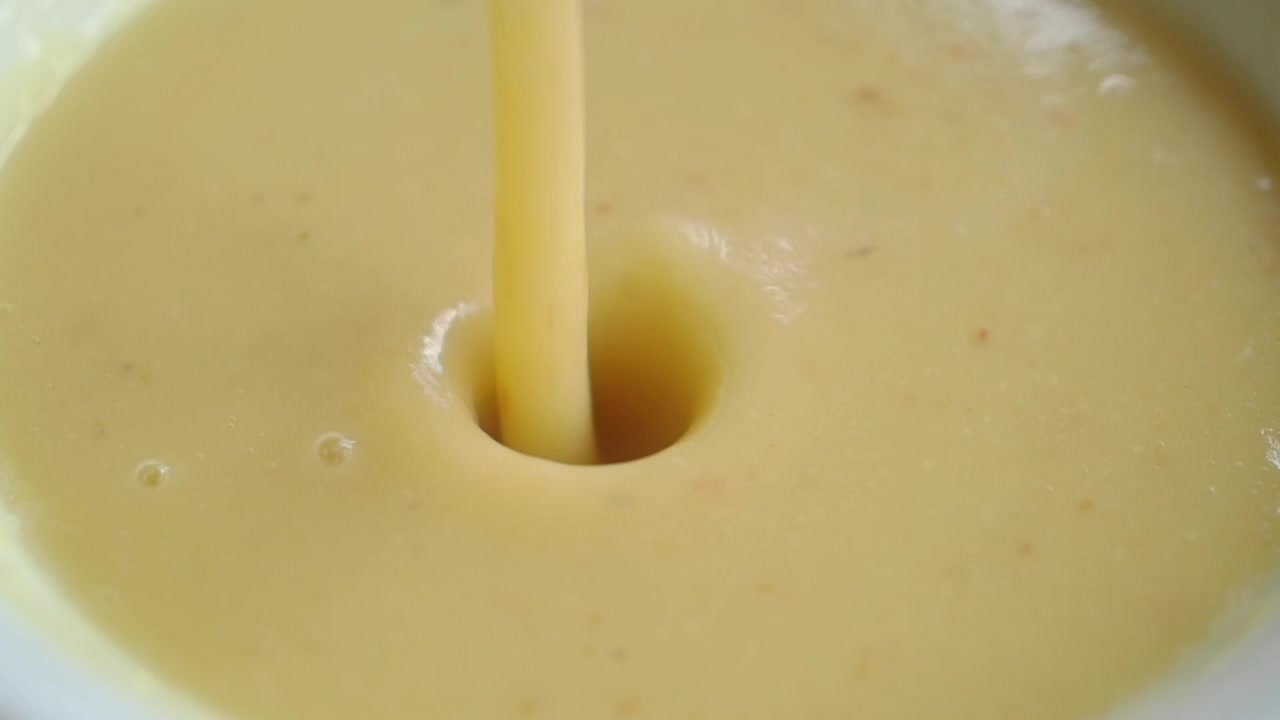 Krémová polévka nalévaná do misky se lžící