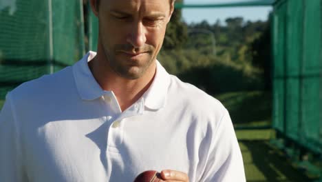 confident cricket player holding ball during a practice session