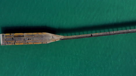 People-walking-on-an-old-historic-wharf-at-Tolaga-Bay,-New-Zealand