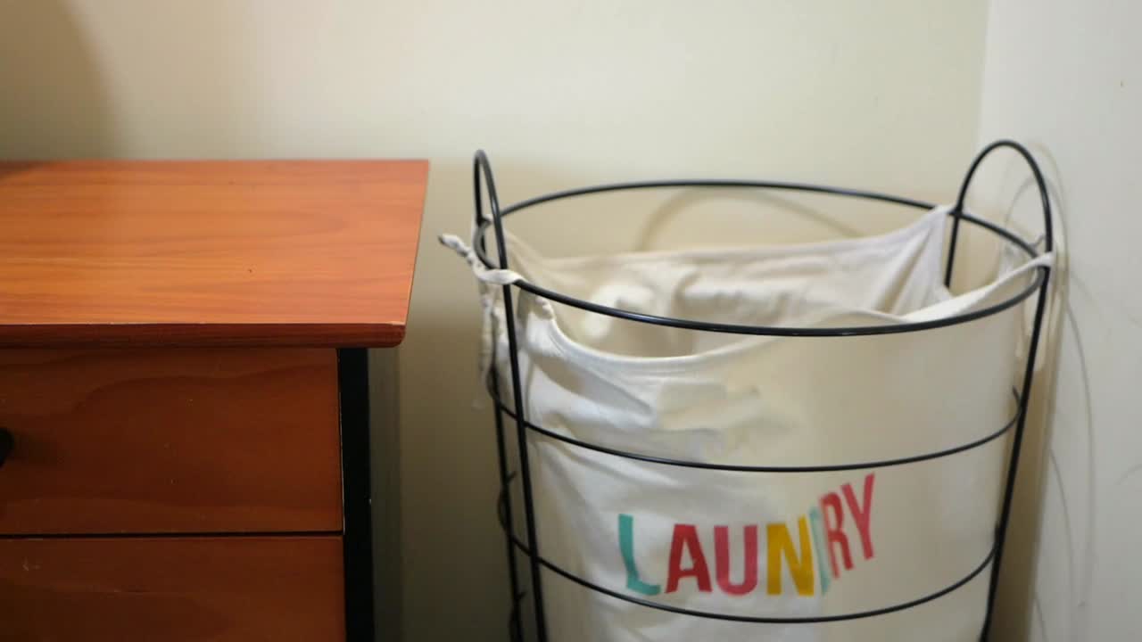 Cloths being tossed into a laundry hamper