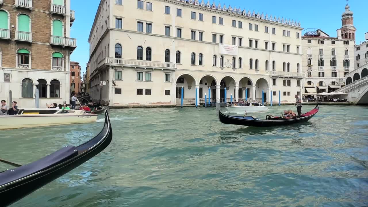 Low angle close up of tourists sightseeing on gondolas and boats traveling through grand canal in Venice, Italy