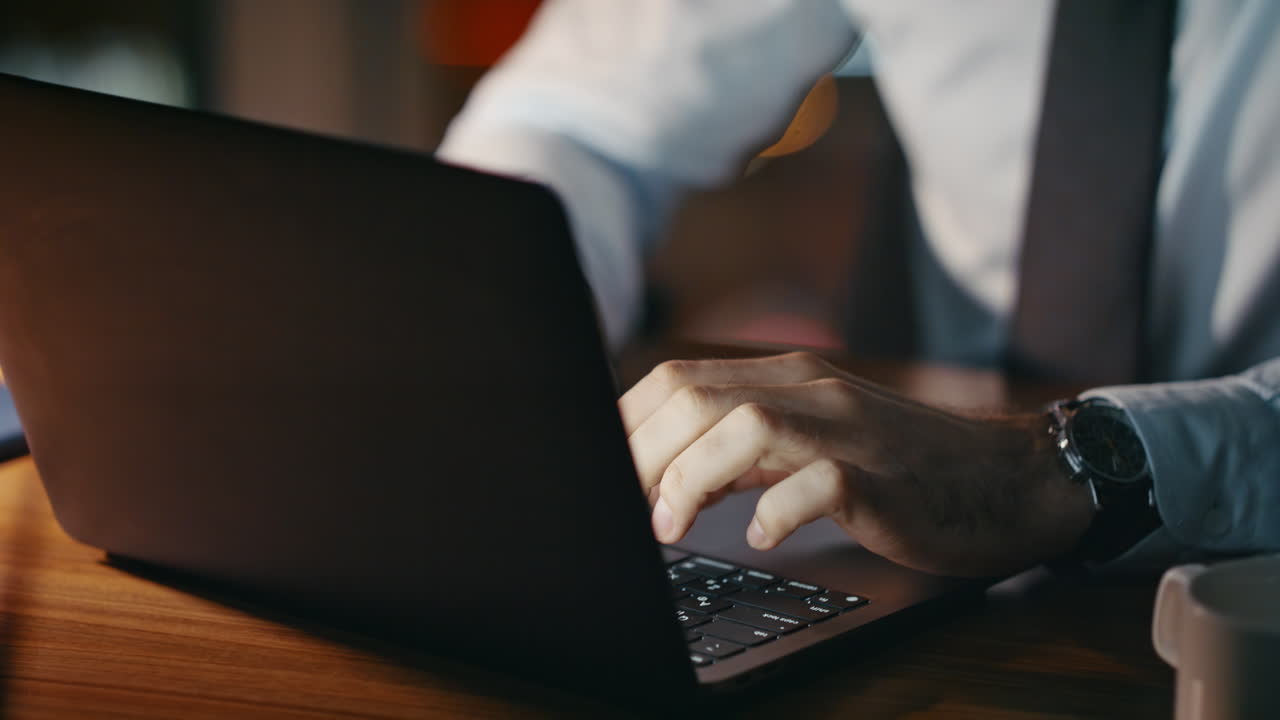 어두운 직장에서 늦은 저녁에 노트북으로 일하는 압도적인 기업가.