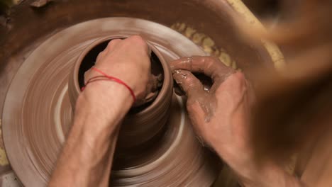 close-up of male hands making a clay bowl on a potter's wheel. handicraft and production of exclusive tea ware made of clay