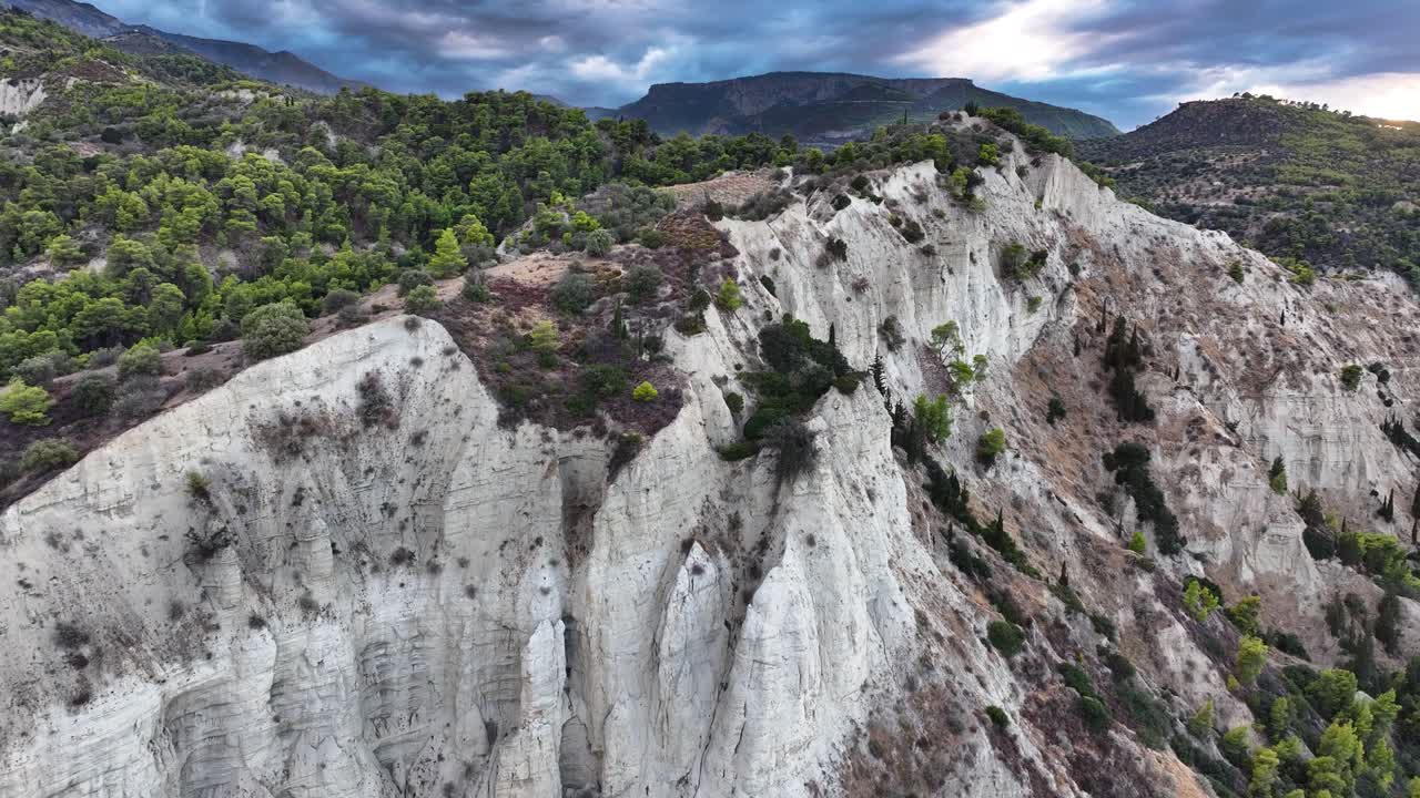 푸른 소나무 숲과 대조되는 색 절벽, 서쪽 그리스의 어고 극적인 폭풍우 구름을 배경으로 설정.