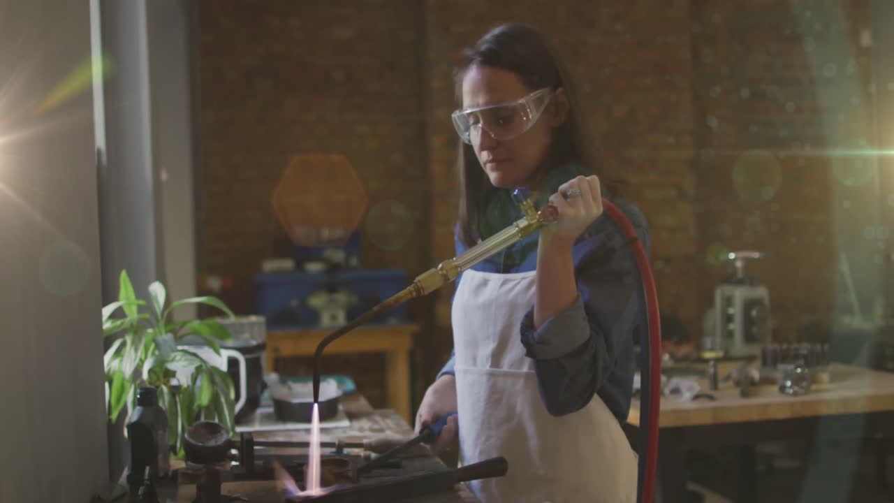 Animazione di luce luminosa su donna caucasica che lavora in officina