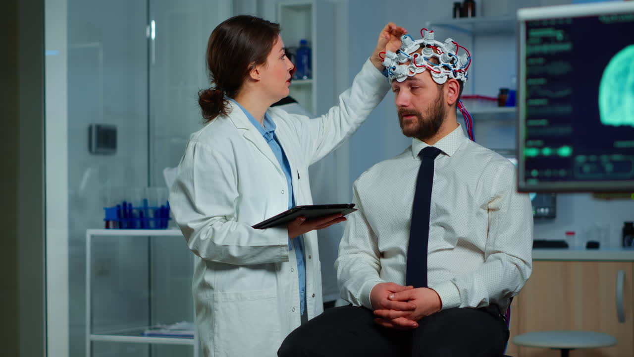 Man sitting on neurological chair with brainwave scanning headset