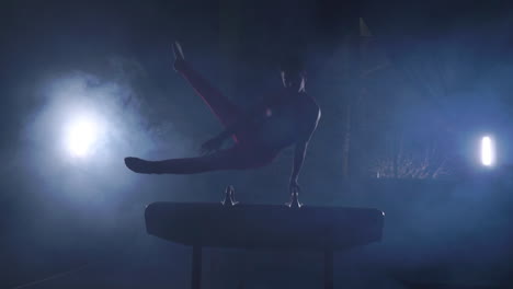 male gymnast performs exercises from the olympic program on pommel horse performing spins and rolls in slow motion