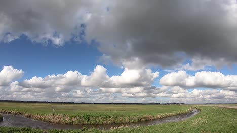 Kumuluswolken-Bewegen-Sich-Am-Blauen-Himmel-über-Einem-Grünen-Feld