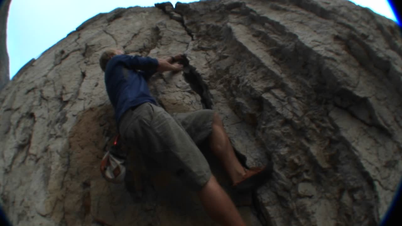 siguiente toma de un escalador escalando un acantilado
