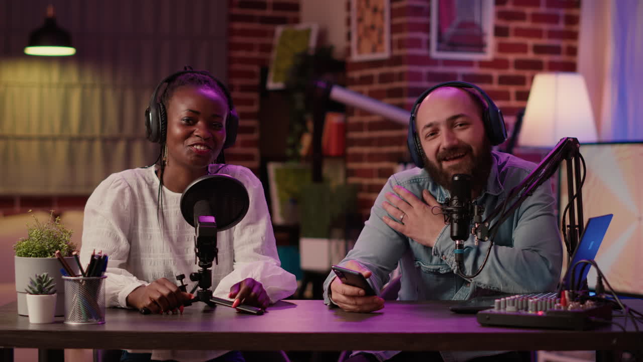 Diverse team of online radio hosts recording podcast review for smartphone streaming audio