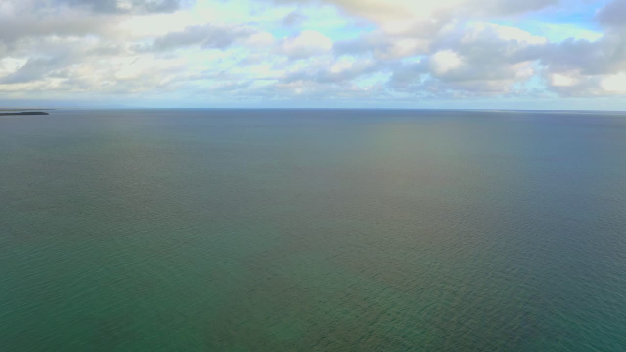 흐린 날 수평선을 드러내기 위해 카메라가 위로 기울어지는 동안 바다 위를 날다