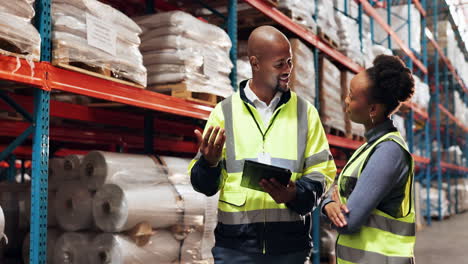 two workers in a warehouse looking at a tablet