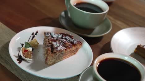 postre de pastel de nueces en una mesa de un restaurante de cafetería, acompañado de tazas de café