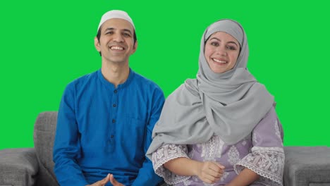 una pareja musulmana feliz haciendo una pantalla verde adaab