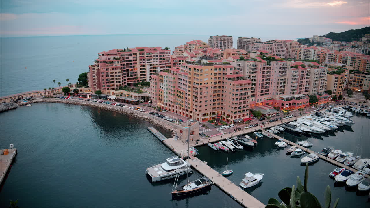 Aerial view of boats docked in the Port de Fontvieille with the skyline of Monaco on the background in the evening