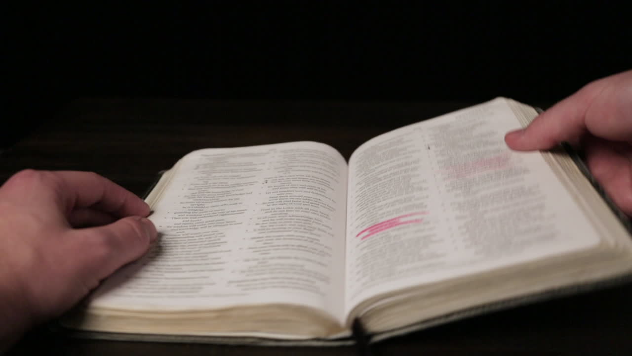 manos masculinas caucásicas hojeando rápidamente las páginas de la biblia: de cerca