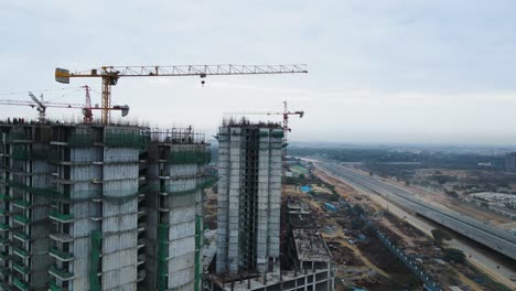 aerial drone shot displaying the transformation of an upcoming commercial hub near dwarka expressway, with numerous buildings rising from the ground.