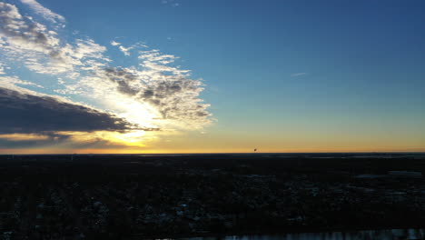 Ein-Goldener-Sonnenaufgang-Mit-Blauem-Himmel-Und-Einigen-Wolken,-Die-Die-Sonne-Umgeben