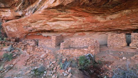 cliff dwelling ruins in red rock cliffs of sedona pan left, pull out reveal village