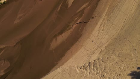 vista aérea circular de la familia de vacaciones caminando por la orilla del río durante el caluroso día de verano en argentina