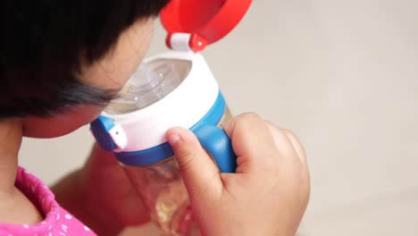 child drinking from a water bottle