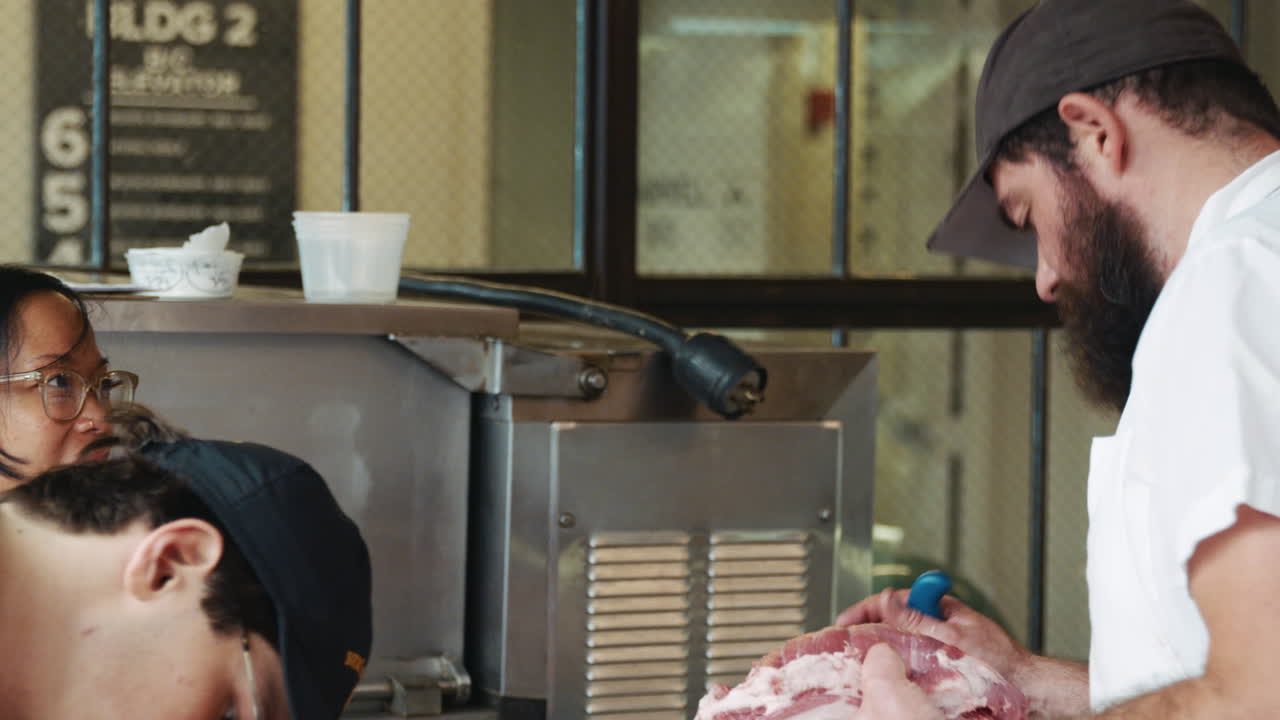 Butchers talk as they prepare meat at a butcher's shop