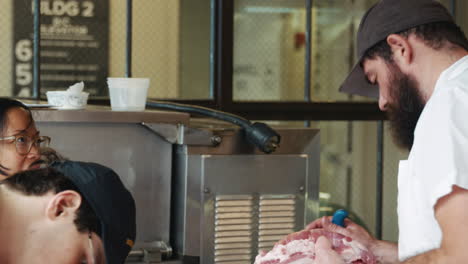 los carniceros hablan mientras preparan la carne en una carnicería