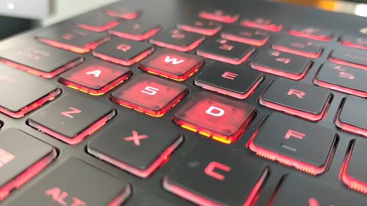 Laptop keyboard close-up. The most common gaming keys, W, A, S, and D, used for directional input, known as the WASD keys. Has the red backlight.