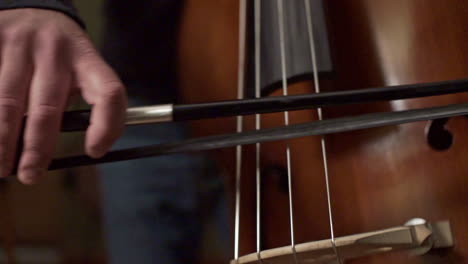 imágenes de un músico tocando un contrabajo con un arco