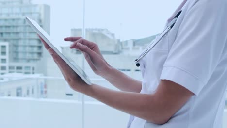 animation of geometric figures over caucasian female doctor using tablet