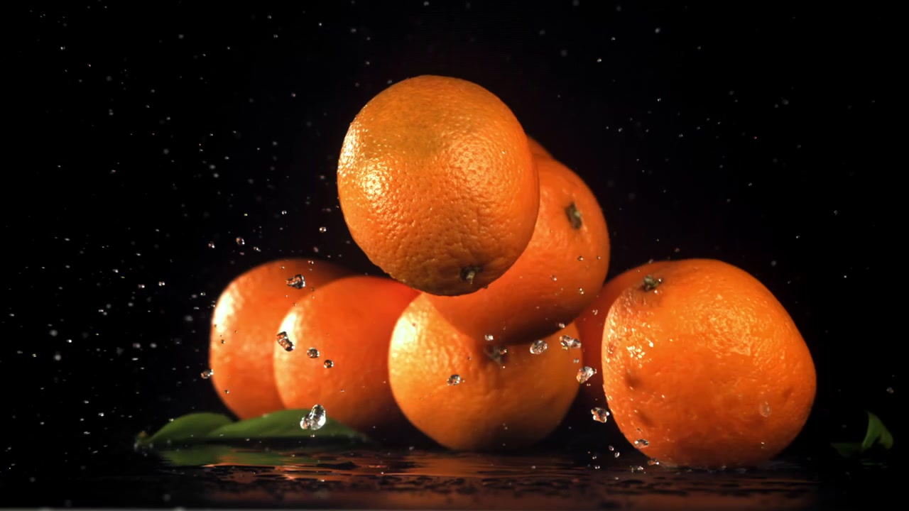 Arance fresche che cadono in super slow motion con schizzi d'acqua