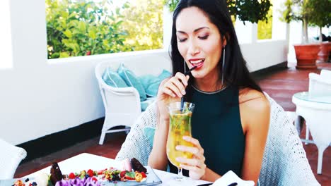 beautiful woman drinking mocktail while having meal