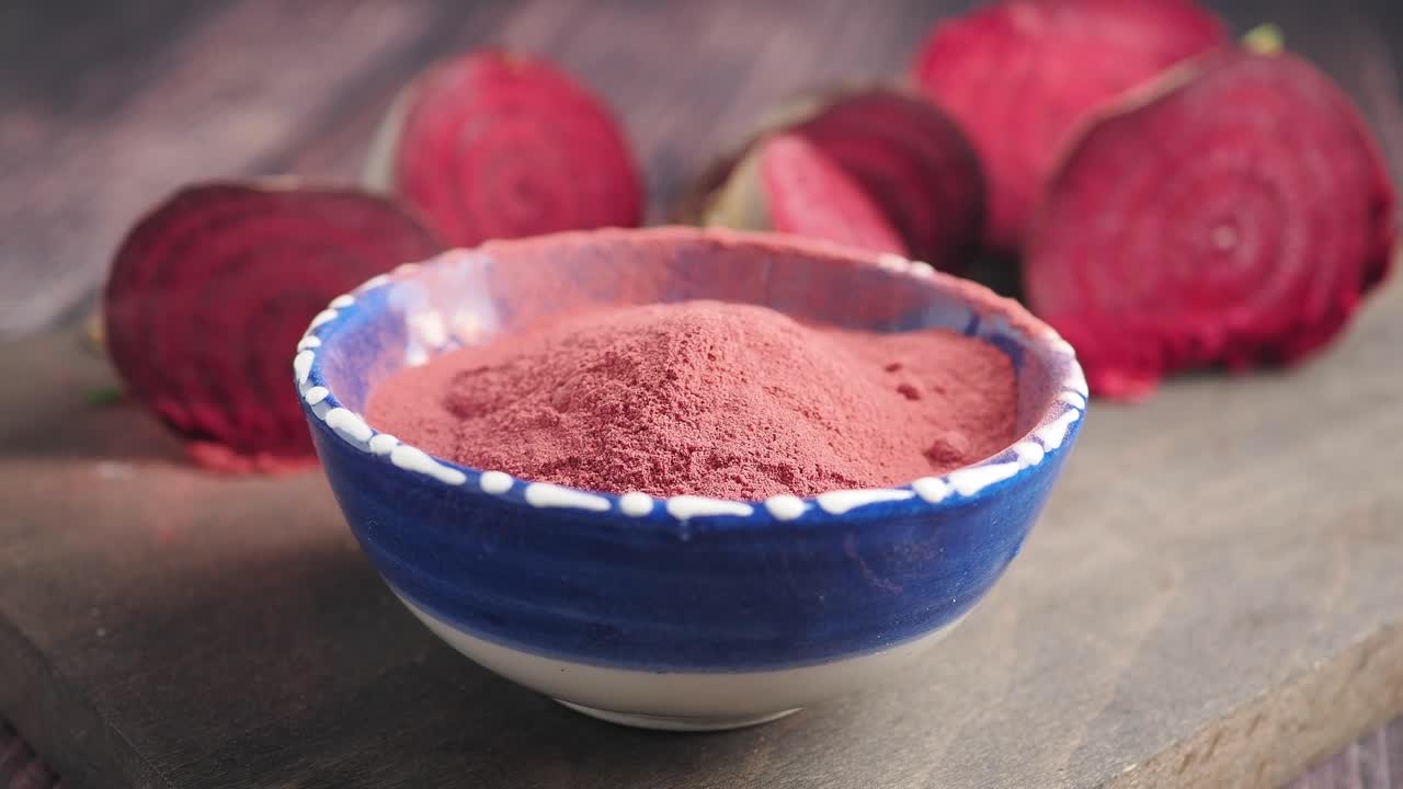 Beetroot Powder in Bowl with Fresh Beets on Wooden Board