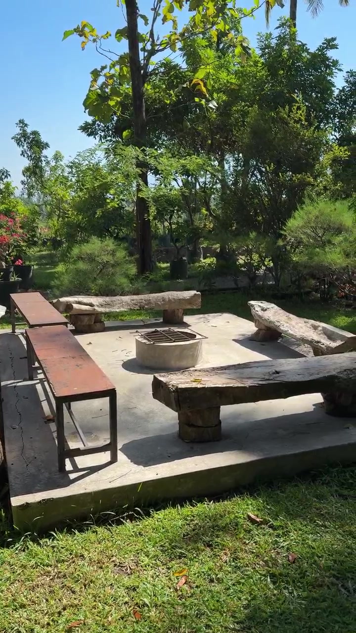 Outdoor Fire Pit Area with Wooden Benches in a Lush Garden